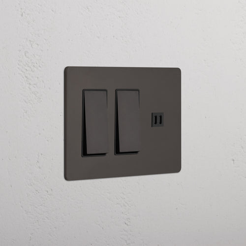 Bronze Black Grove 3G switch plate with two rocker switches and fast charge USB port, on a white wall.