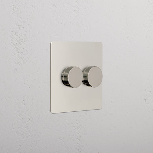 Kew 2G Dimmer Switch in polished nickel with two round knobs on a square plate, mounted on a wall.