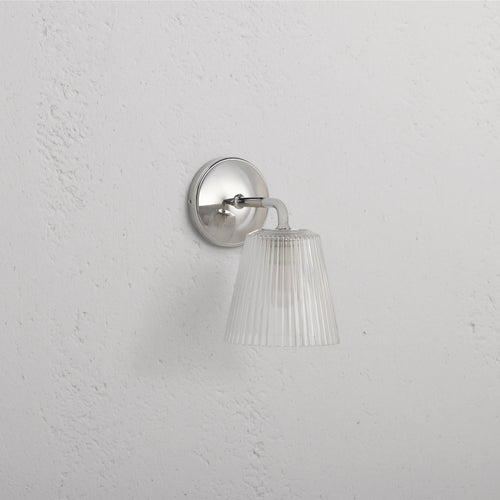 Richmond Medium Wall Light Fluted Glass in polished nickel with ribbed glass shade, mounted on a white wall.
