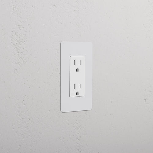 Kew 1G 15A Outlet in paintable white finish, single socket, shown installed on a white wall.