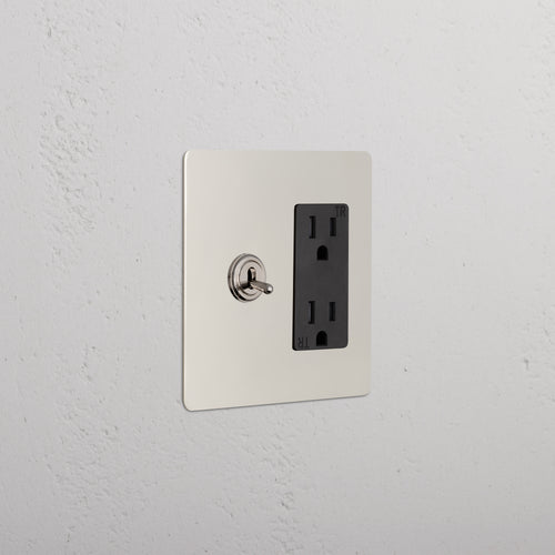 Kew 2G Toggle Switch & Outlet in polished nickel black with left toggle switch and right dual outlet on wall.