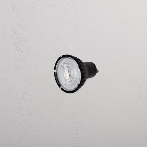 Arthur 7.5W 50mm LED GU10 24° Bulb with black casing displayed against a textured white background.