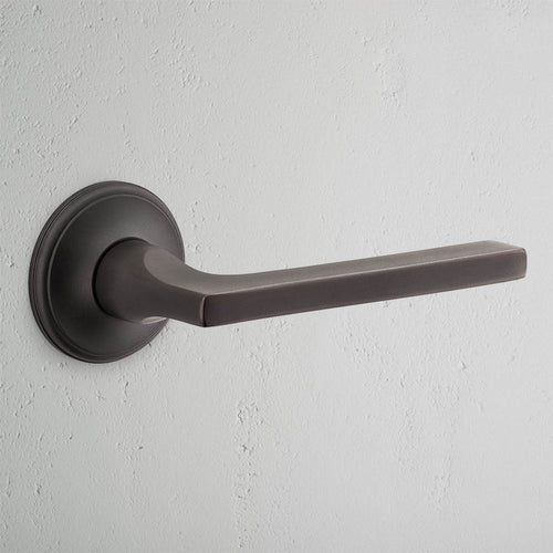 Clayton Unsprung Passage Door Handle Set in bronze finish with a sleek, minimalist design and round base plate.