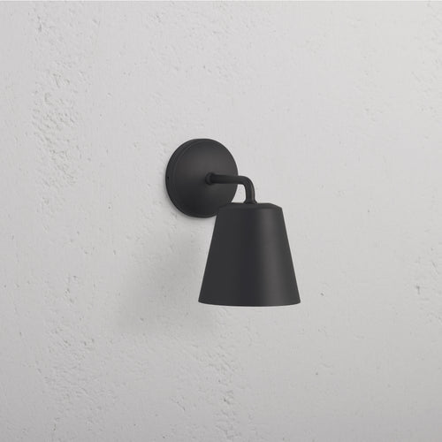 Richmond Medium Wall Light in bronze finish with a conical shade, mounted on a white wall.