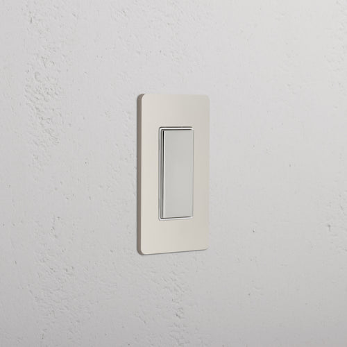 Grove 1G Center Retractive Rocker Switch in polished nickel white, mounted on a white wall.