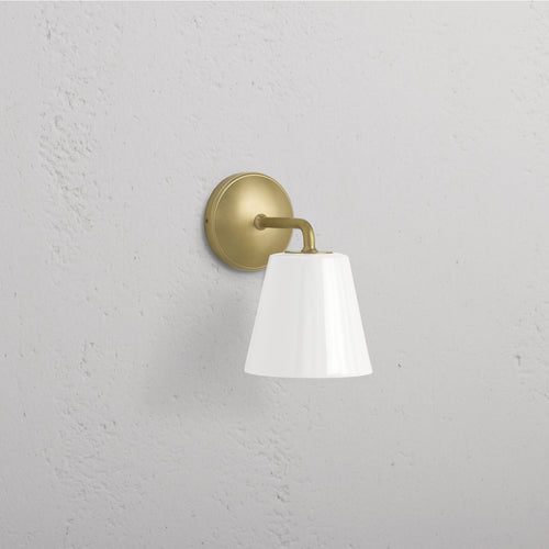 Richmond Medium Wall Light in antique brass with a white fine porcelain shade, mounted on a wall.