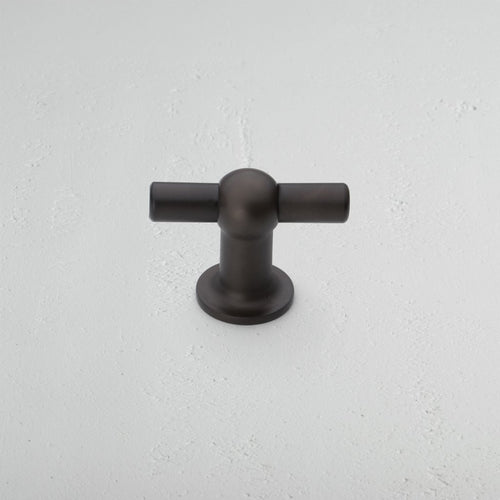 Harper T-Bar Furniture Handle Medium in bronze, featuring a sleek T-shaped design on a white surface.