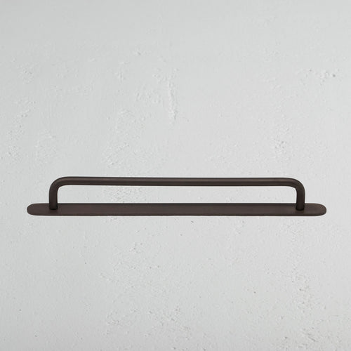 Medium-sized Kilburn Furniture Handle in bronze finish, mounted horizontally on a white wall.