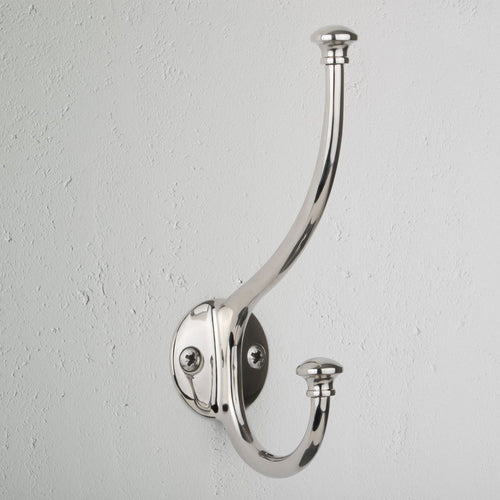 Polished Nickel Mews Hook with two curved prongs mounted on a textured white wall.