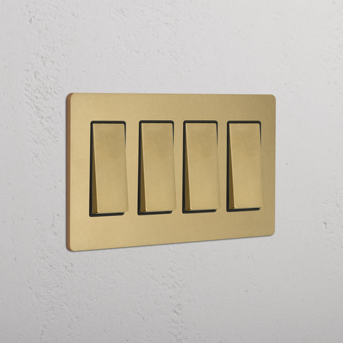 Grove 4G Rocker Switch in Antique Brass Black with four rectangular switches on a white wall.