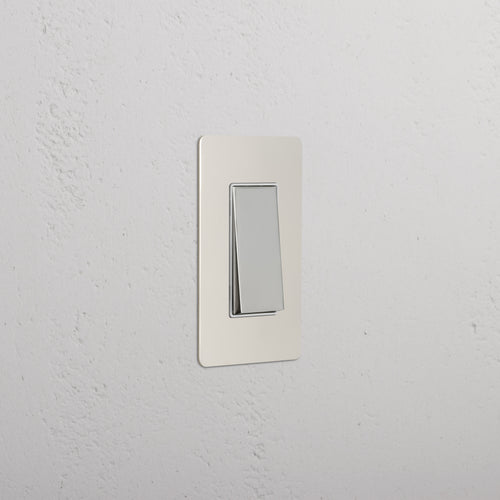 Kew 1G Retractive Rocker Switch in polished nickel with white faceplate, mounted on a white wall.