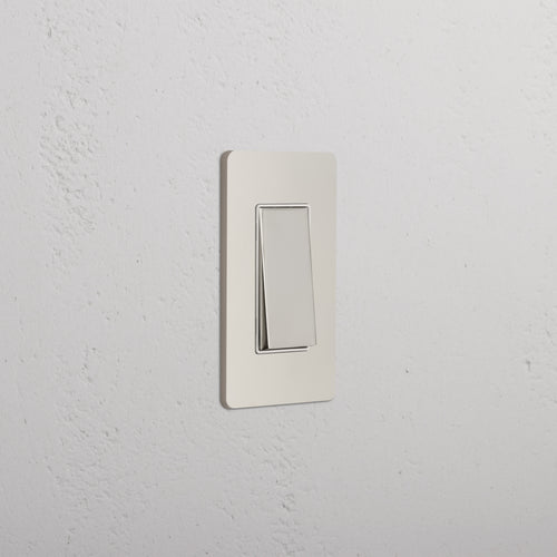 Grove 1G Retractive Rocker Switch in polished nickel white finish, mounted on a white textured wall.