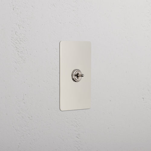 Kew 1G Center Retractive Toggle Switch in polished nickel mounted on a rectangular plate.