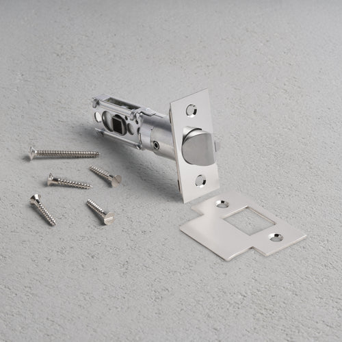 Passage Tubular Latch in polished nickel with faceplate, strike plate, and screws arranged on a light surface.