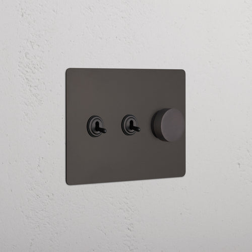 Kew 3G 2x Toggle & Dimmer Switch in bronze with two toggle switches and one round dimmer knob.