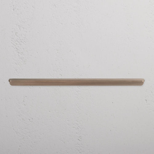 Oxford Furniture Handle Large in antique brass finish, mounted horizontally on a white wall.