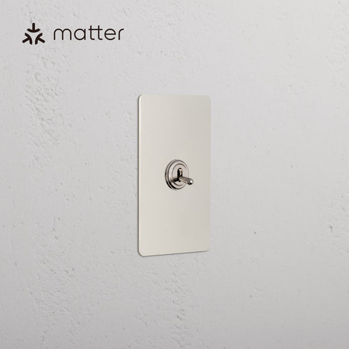 Kew 1G Smart Retractive Toggle Switch in polished nickel finish, mounted on a white wall with Matter logo.